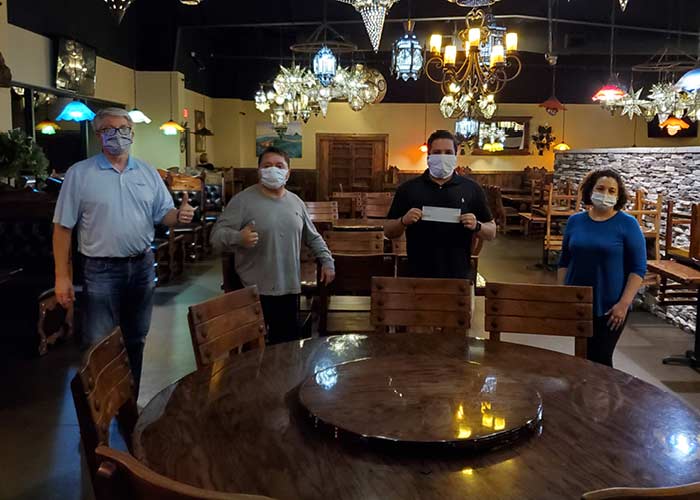 Bankers and restaurant owner wearing masks and completing loan documentation