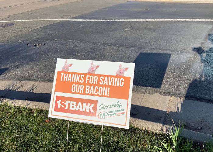A sign says, "Thanks for Saving Our Bacon"