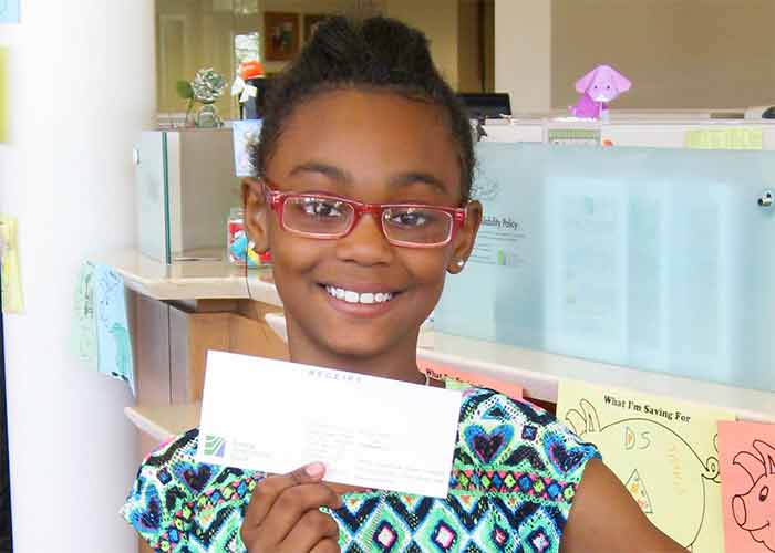 Nyla holding a check