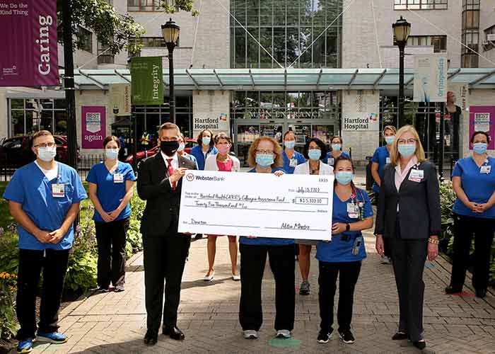 Webster Bank employees hold an oversized check