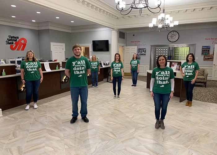 Bank employees stand socially distant in the bank lobby