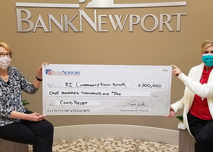 Two bank employees hold an oversized check to the Rhode Island Community Food Bank