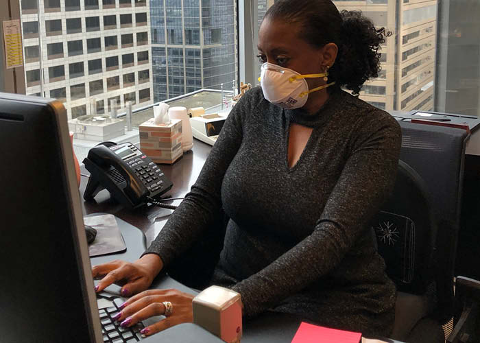 A banker works while wearing a mask